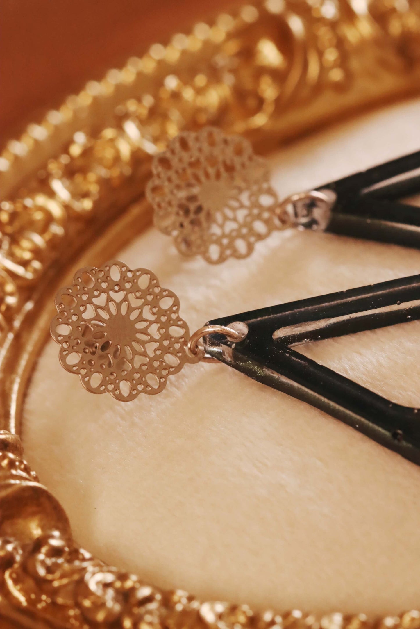 Close-up of the silver filigree earring post used for the Floral Romance Resin Earrings - part of the Gothic Romance Jewelry Collection by Kaleidoscopes And Polka Dots. These earrings feature a midnight blue background and are displayed on a beige jewelry tray with gold trim.