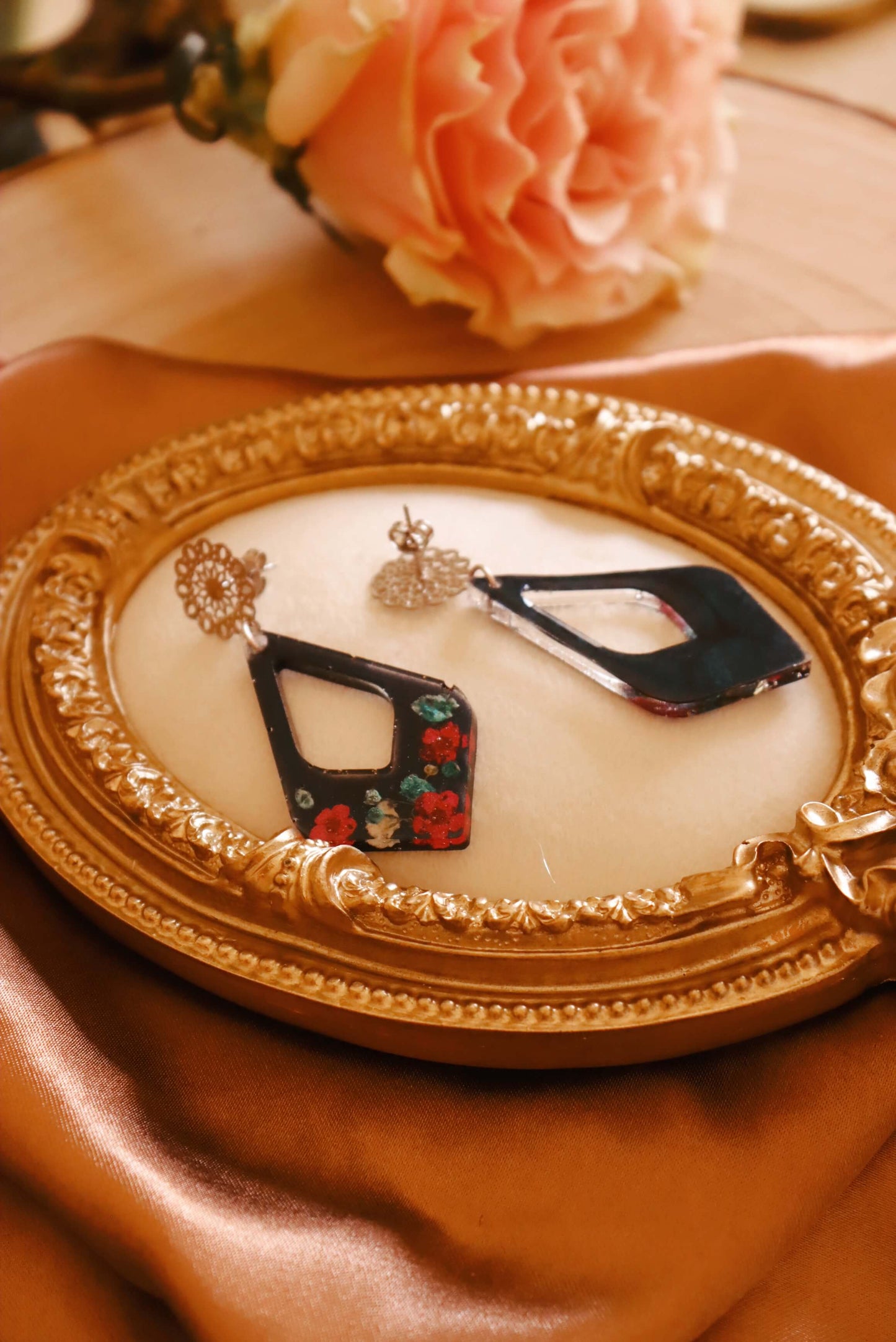 Font and back view of the Floral Romance Resin Earrings - part of the Gothic Romance Jewelry Collection by Kaleidoscopes And Polka Dots. These earrings feature a midnight blue background and are displayed on a beige jewelry tray with gold trim.