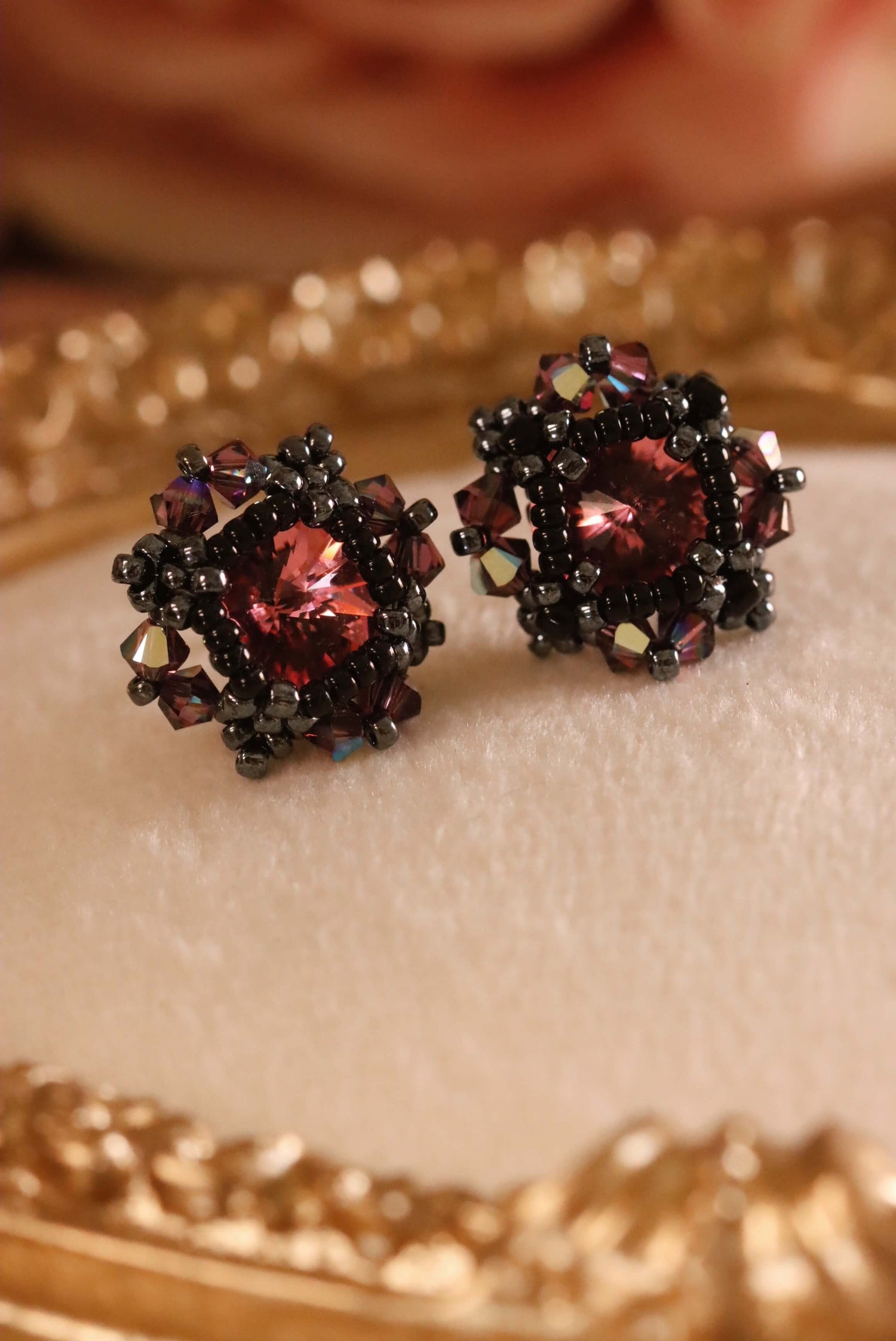 Gothic Pink Crystal Stud Earrings, part of the Gothic Romance Collection by Kaleidoscopes And Polka Dots, set against a beige background with gold trim.