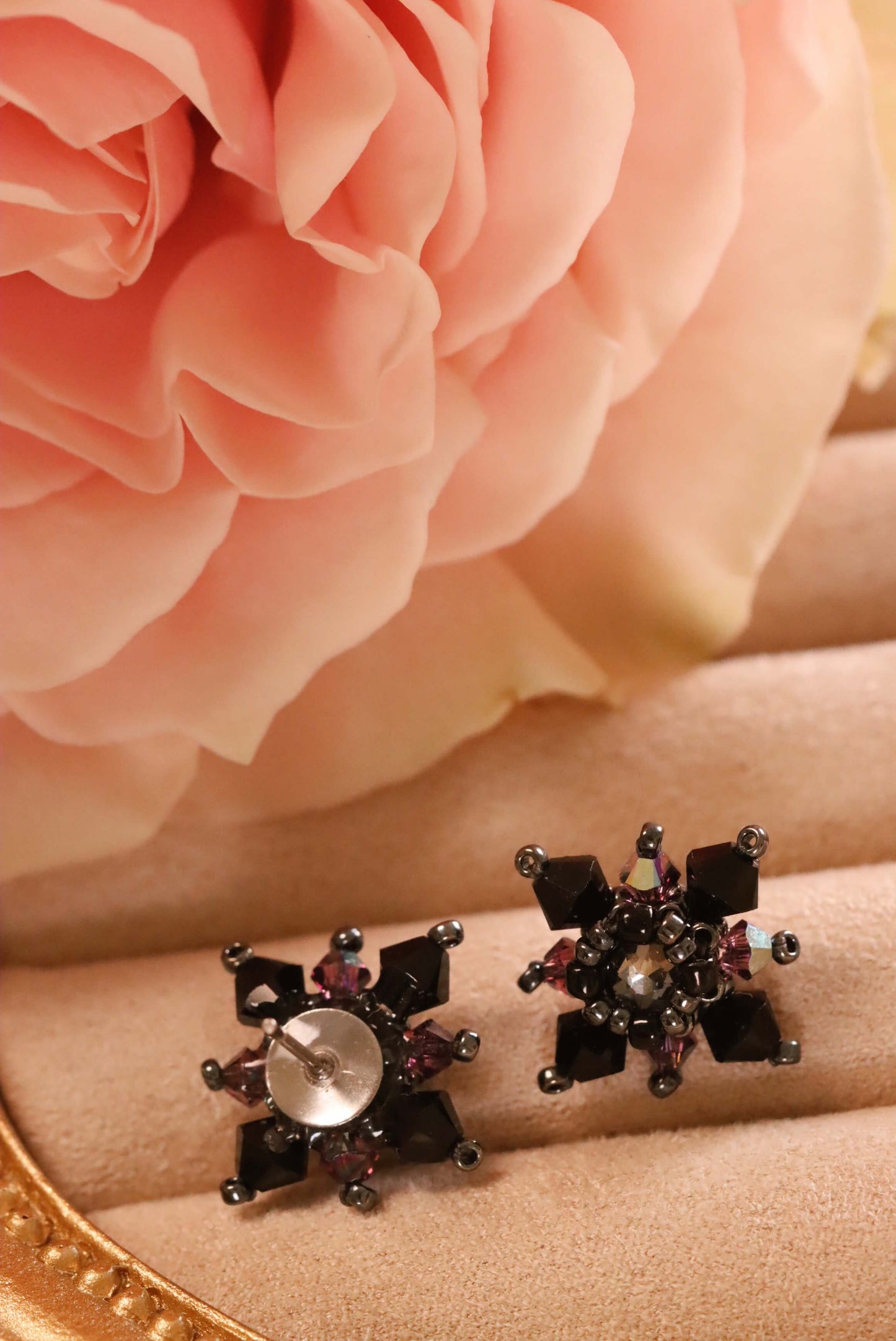 Gothic Stud Earrings- a close-up of the front and back of these earrings, which are part of the Gothic Romance Jewelry Collection. These stud earrings are set against a beige jewelry display and a pink rose. 